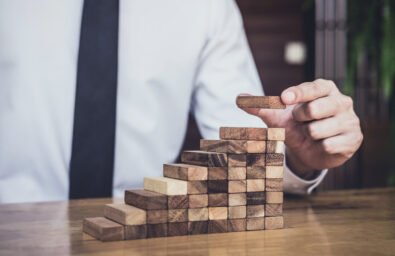 Risk,To,Make,Business,Growth,Concept,With,Wooden,Blocks,,Hand Building Blocs